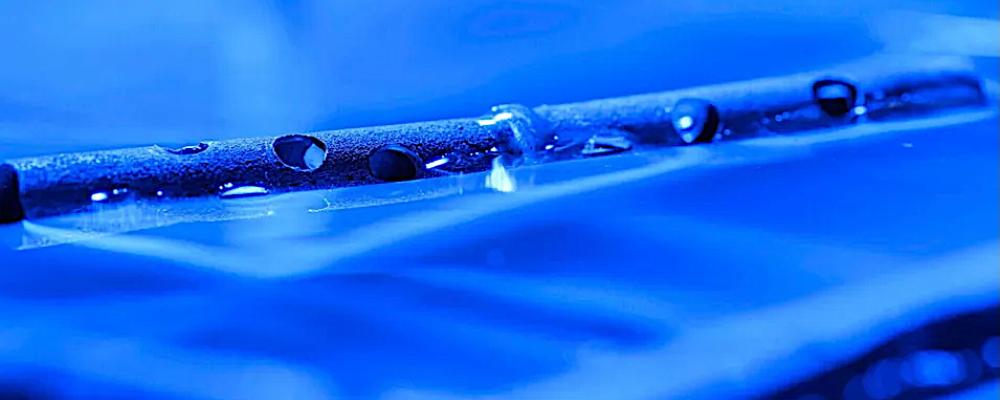 Metall behandlad med mikro- och nanostrukturer kan flyta på vatten, även efter att ha borrats med hål. Foto: University of Rochester