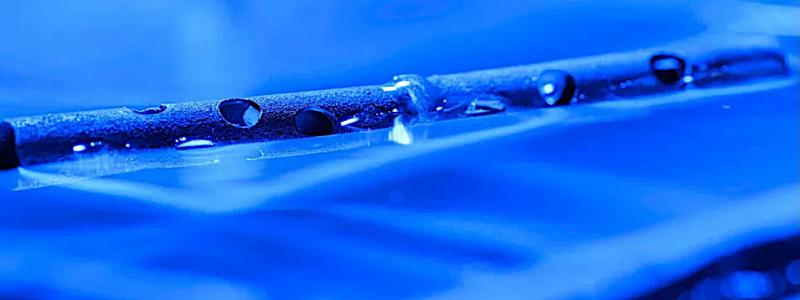 Metall behandlad med mikro- och nanostrukturer kan flyta på vatten, även efter att ha borrats med hål. Foto: University of Rochester