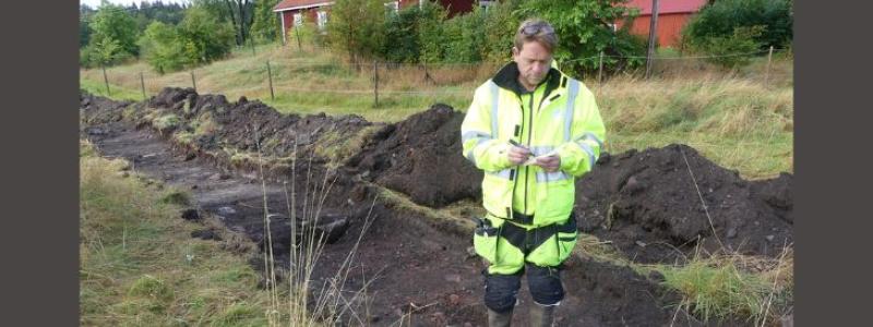 Andreas Hennius, arkeolog vid Upplandsmuseet, vid en arkeologisk undersökning av en yngre järnåldersboplats under arbetet med kartläggningen.  Foto: Malin Lucas, Upplandsmuseet