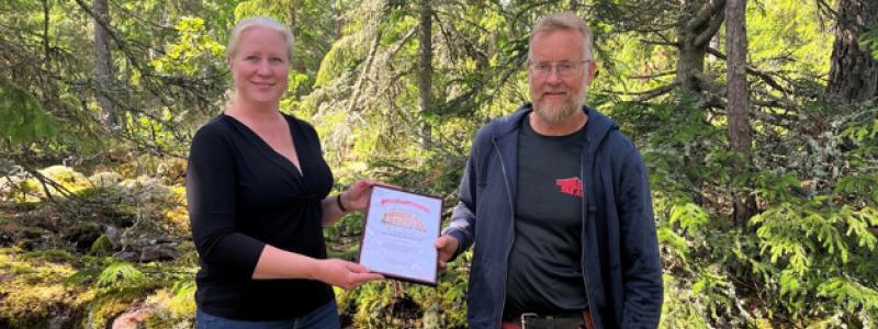 Therese Bejgarn, enhetschef för gruv- och mineralnäringsanalys, delade ut förstapriset till Peter Karlsson direkt på fyndplatsen i Oskarshamn. Foto: Tobias Blixt/SGU