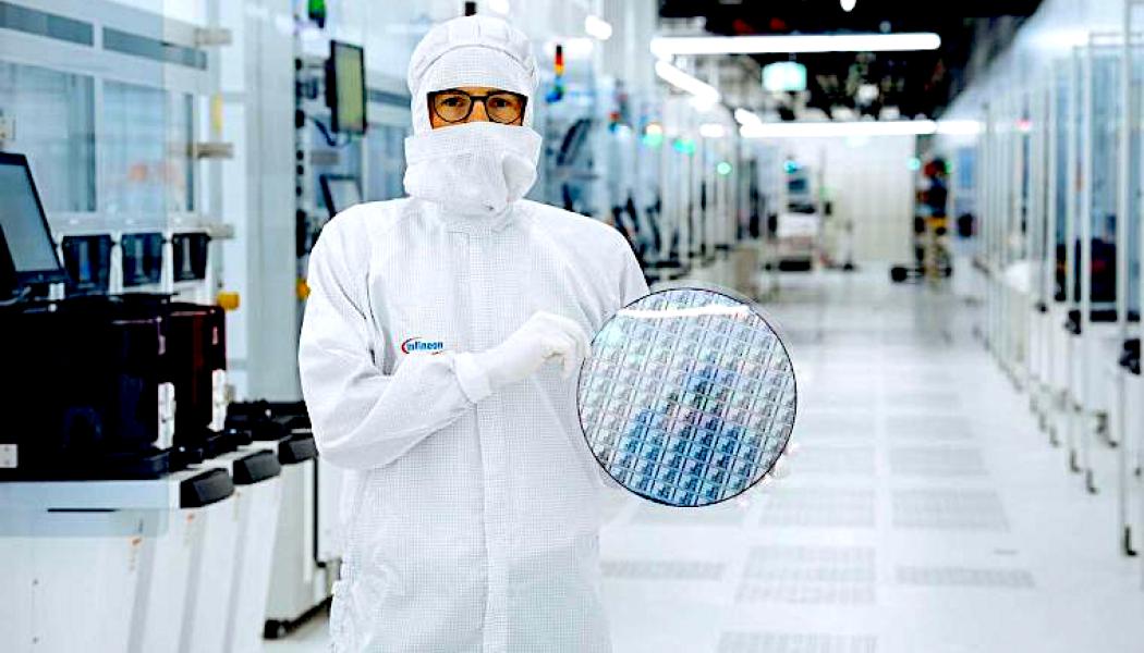 En tekniker i renrummet på Infineon Technologies i Villach, Österrike, håller i ett 300 mm stort galliumnitrid-wafer. Källa: Infineon