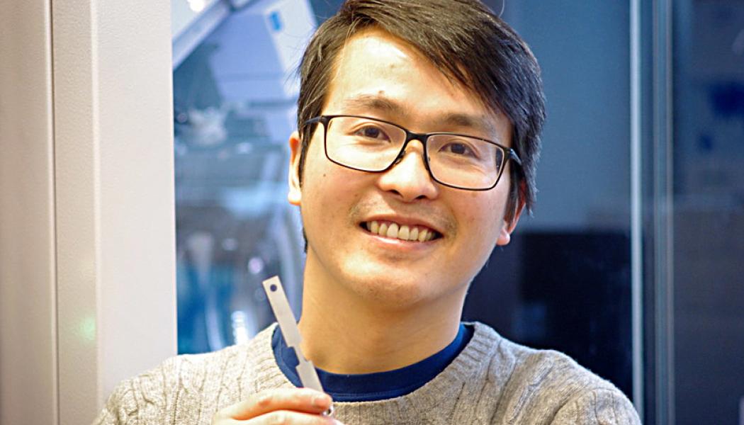 Song Lu, en av forskarna bakom studien, håller i en metallegering som forskarna tagit fram. Foto: KTH