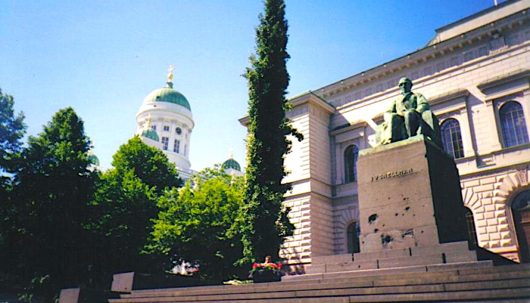 Finlands statsbank med staty av Johan Vilhelm Snellman, skulpterad av Emil Wikström (1864–1942), framför statsbanken i Helsingfors. Statyns fot visar avsiktligt skador från sovjetiska bombningar av Helsingfors under andra världskriget. Foto: Wikipedia Common, kredit: ThePeter